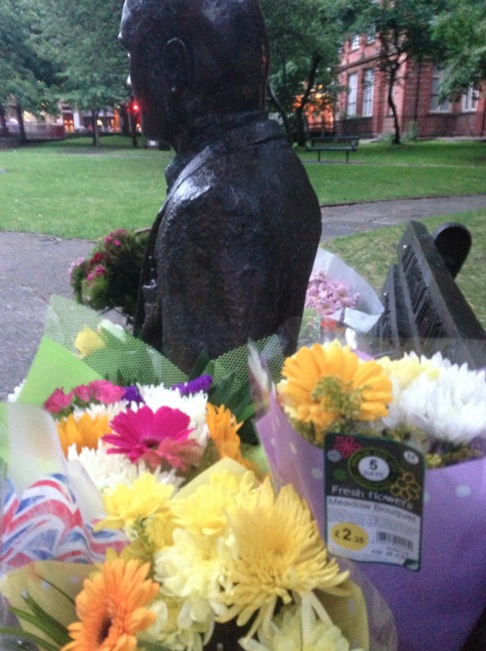 Alan Turing's Statue surrounded by flowers