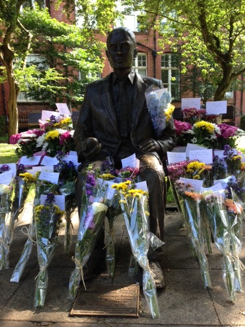 Alan Turing's Statue with lots of flowers