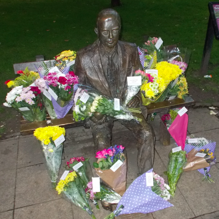 Alan Turing's Statue surrounded by flowers