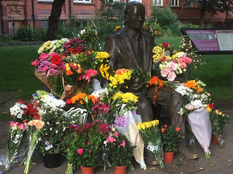 Alan Turing's Statue surrounded by flowers