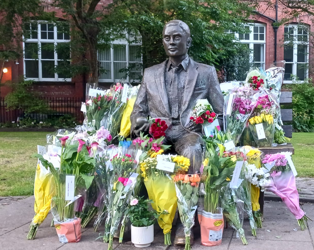 Photo of statue surrounded by flowers